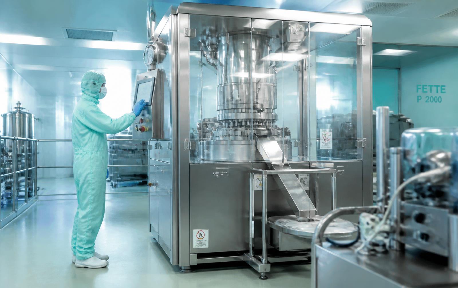 Operator working at a solid dosage manufacturing line in a cleanroom
